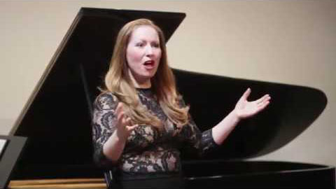Chrisina Raphaëlle Haldane singing beside piano